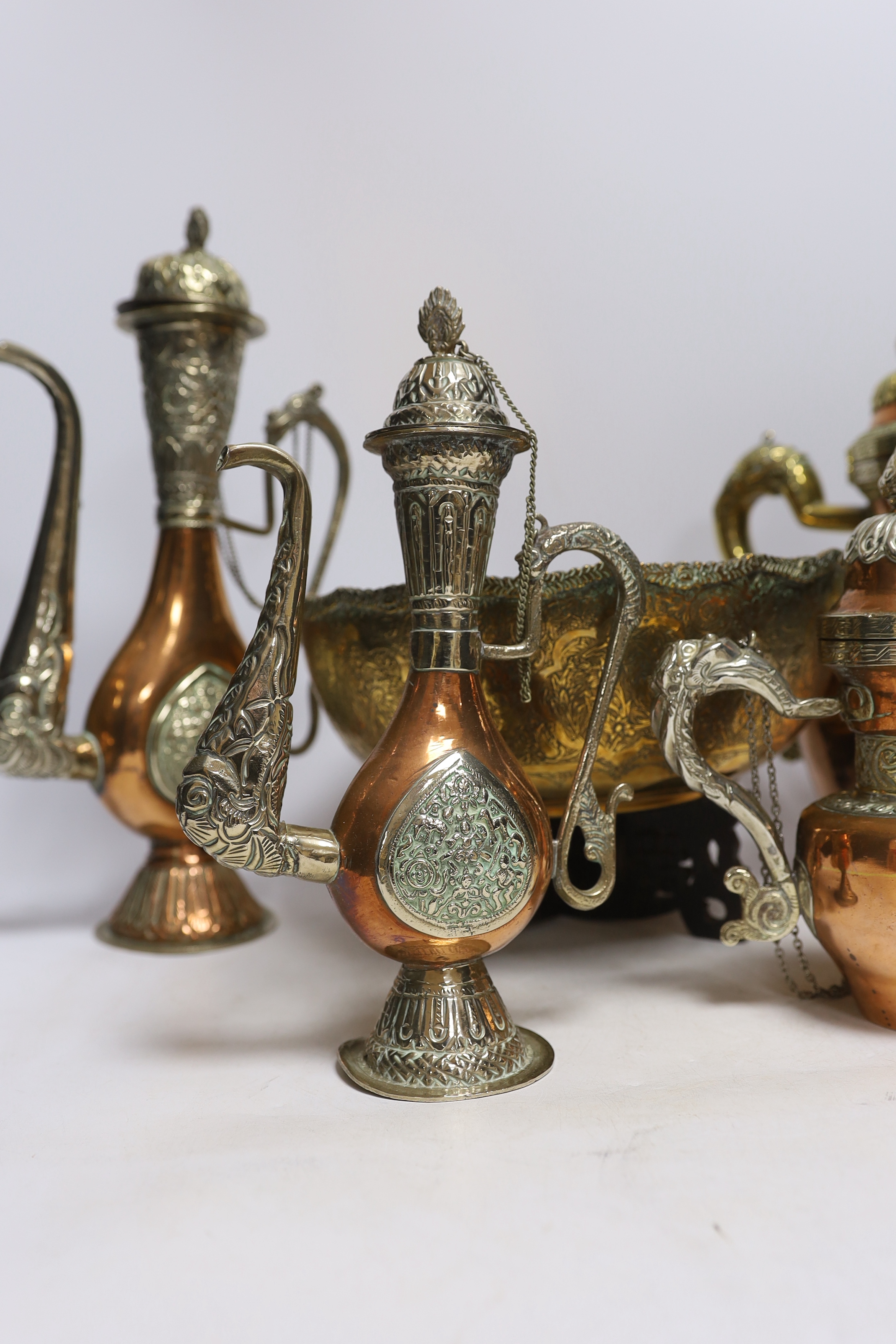 Four Tibetan overlaid copper teapots and an engraved brass bowl, tallest 34cm